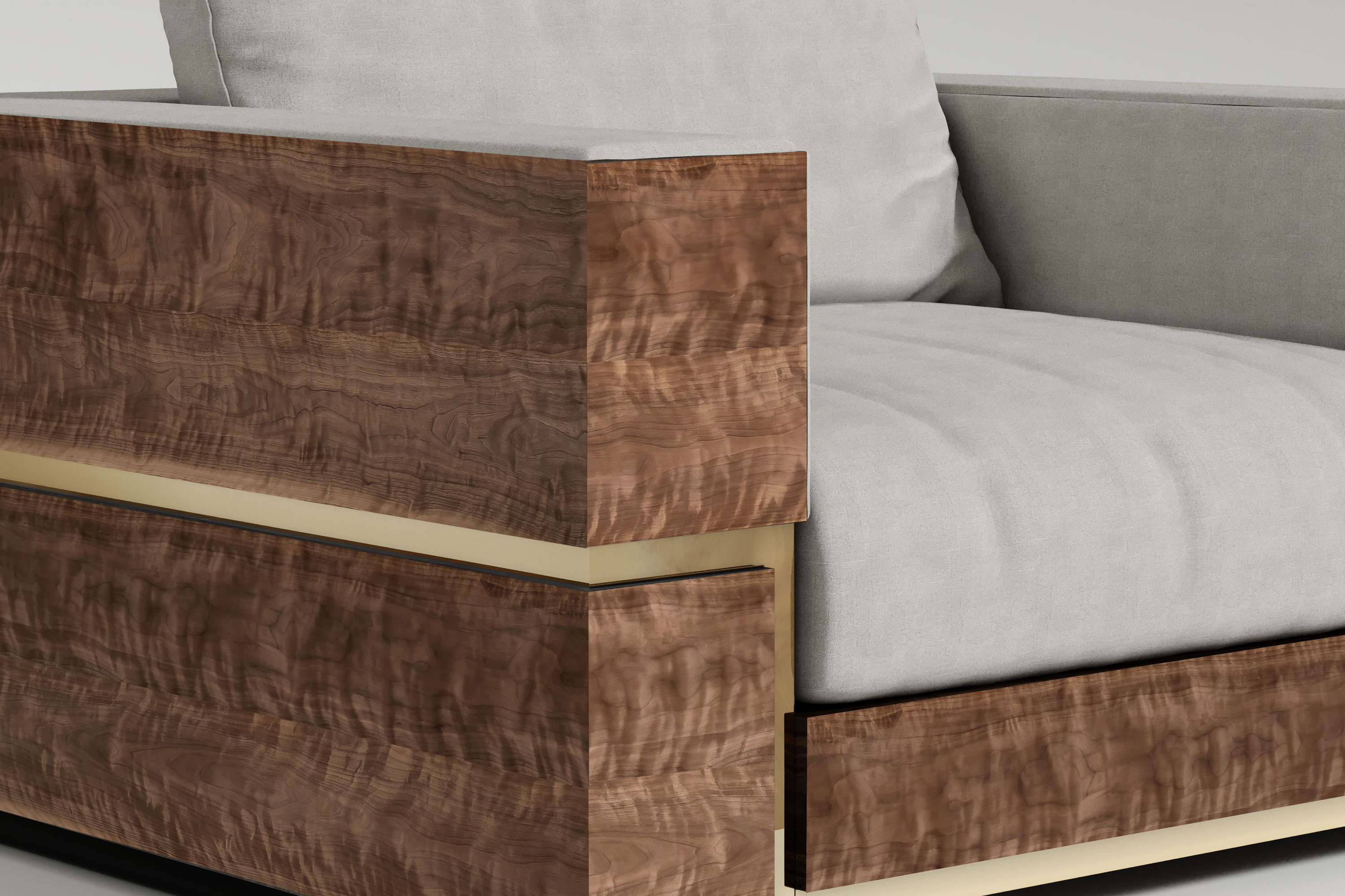 A close-up view of a modern lounge chair with light gray upholstery and armrests made of polished, richly grained wood, featuring a polished bronze trim along the bottom edge, a stunning example of bespoke furniture inspired by Art Deco design.