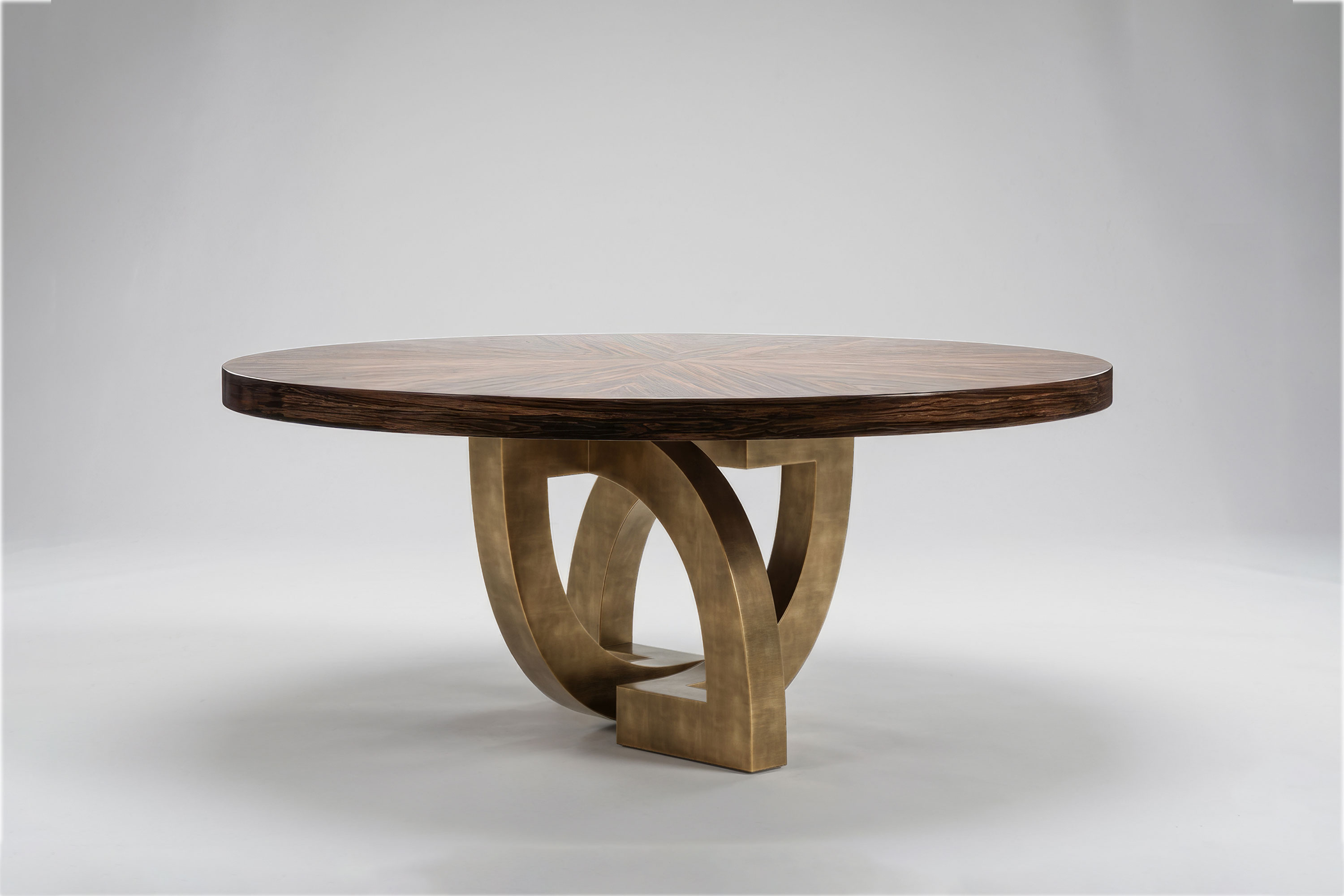 Arco Round dining table by Palena Studio, low angle view of the patina bronze arch base and the sunburst Macassar Ebony top