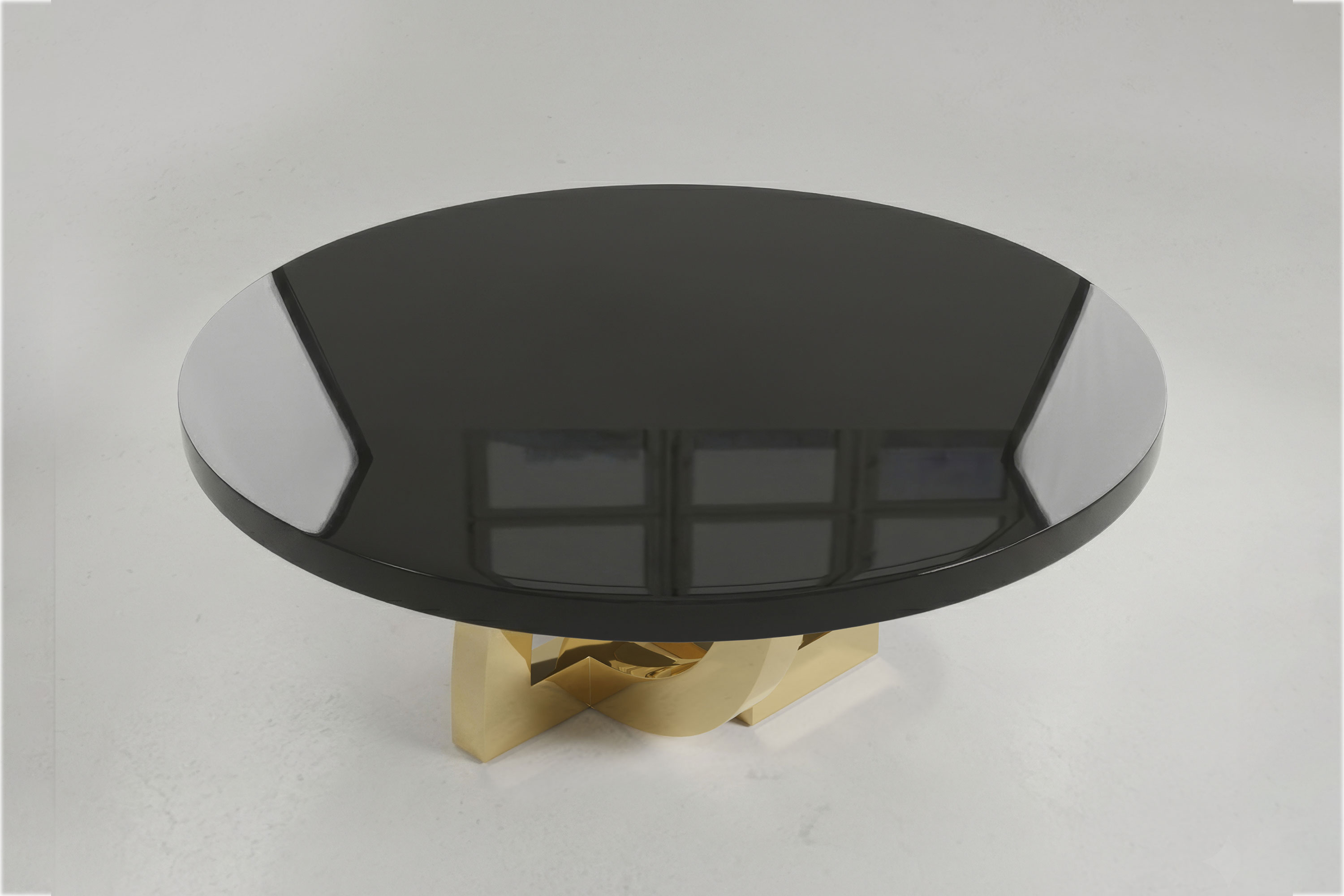 Arco Round dining table by Palena Studio seen from above, the mirror finish obsidian lacquer top on a polished bronze arch base