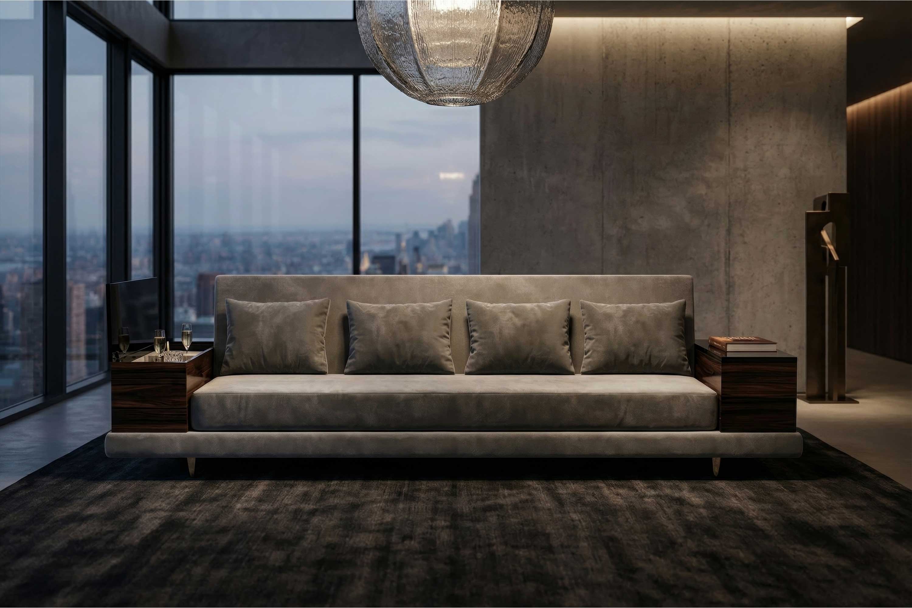 A modern living room with a large grey sofa, five matching cushions, wooden side tables, floor-to-ceiling windows showcasing a city view, and a round, textured ceiling light. The room features a minimalist, neutral-toned design accented by handmade details.