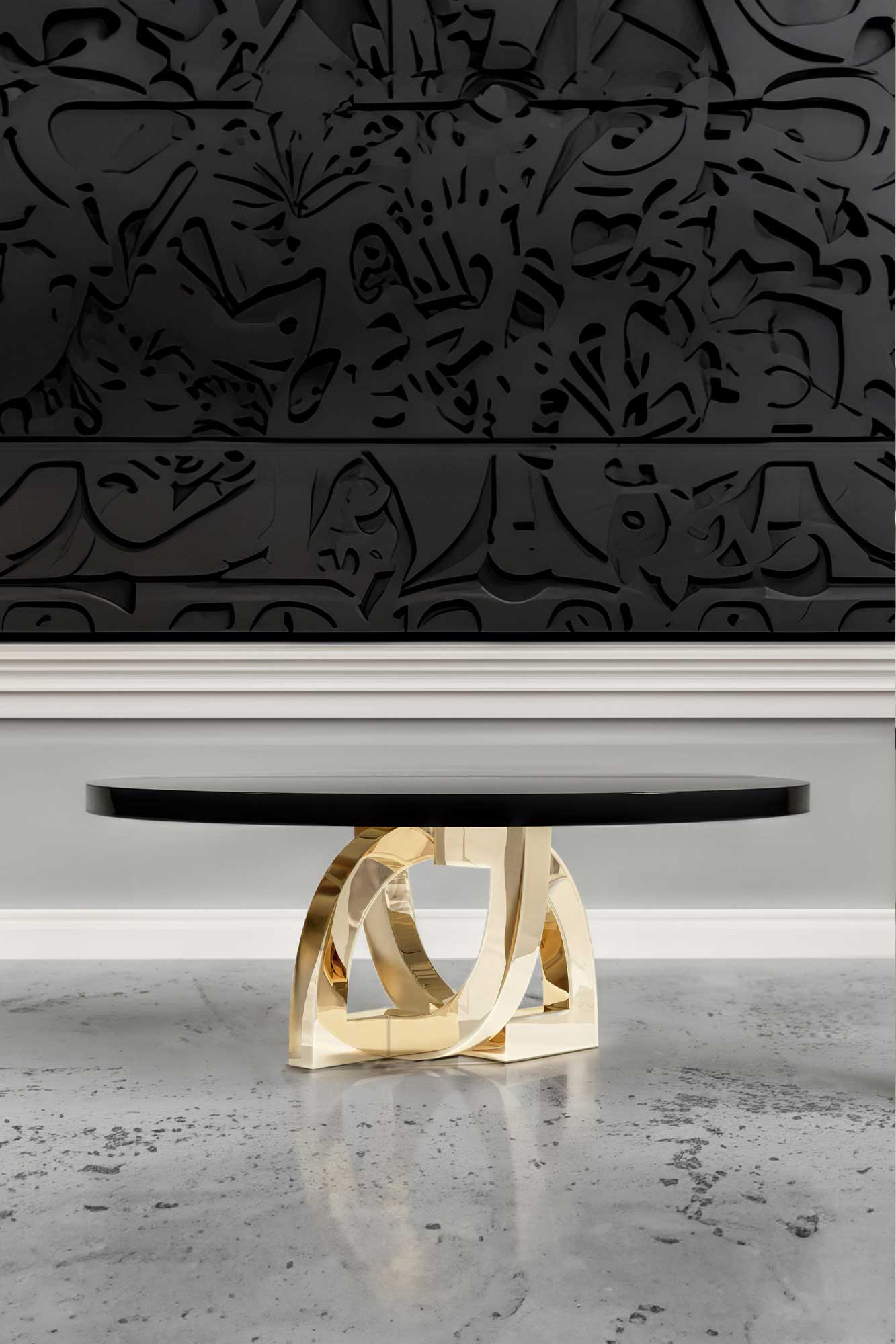 Arco Dining Table in polished bronze, sculptural arc-base dining table staged in a dark contemporary interior with ornate carved wall, Palena Studio