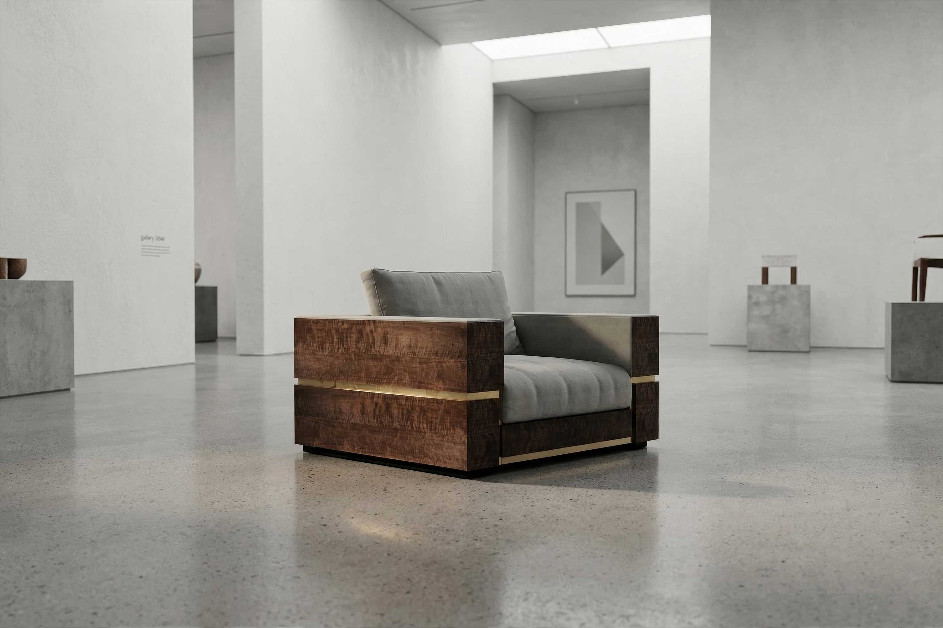A modern armchair with wooden sides and a gray cushion, crafted as bespoke furniture, sits in the center of a spacious, minimalist art gallery with polished concrete floors and white walls.