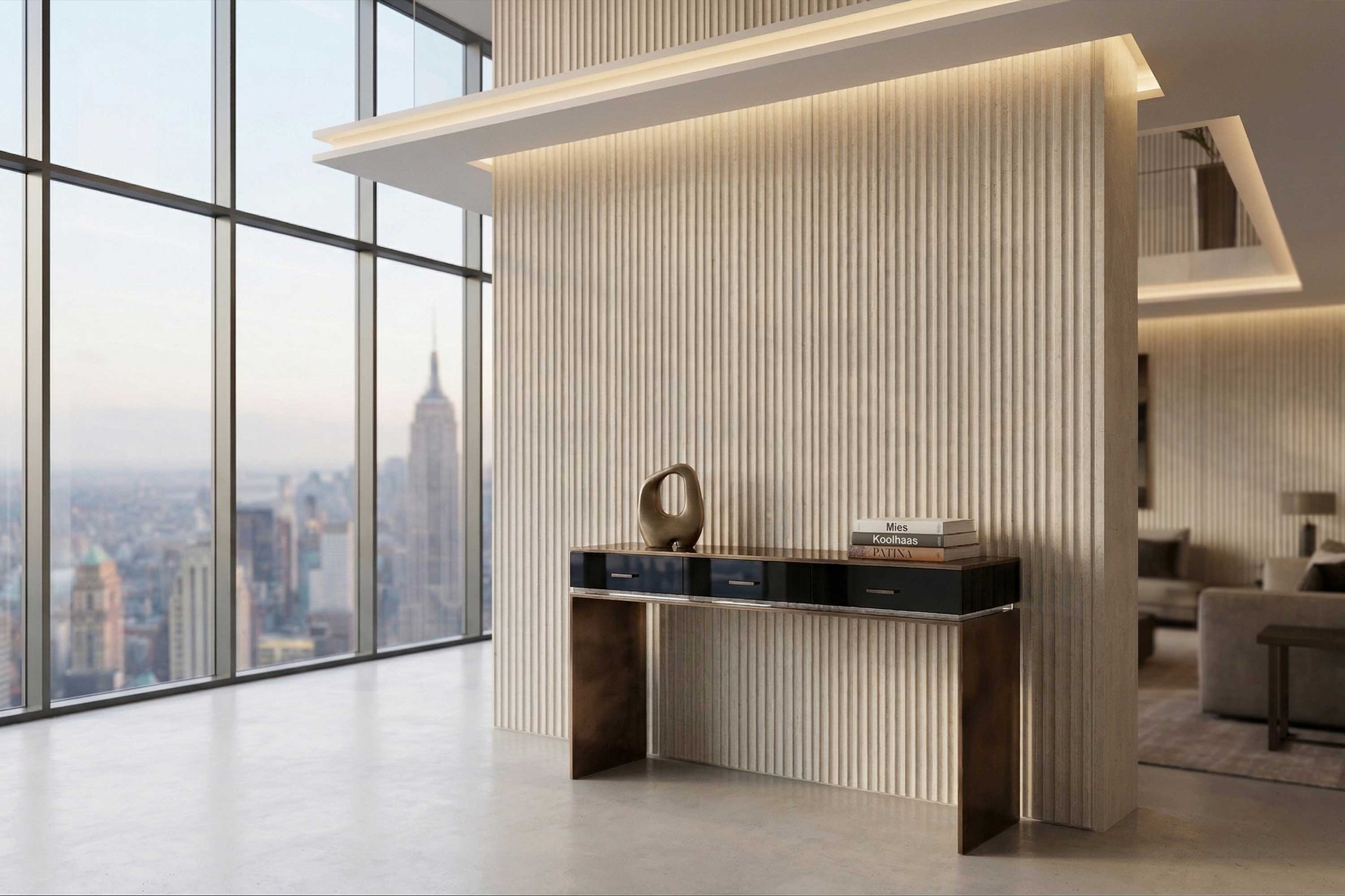 Modern interior with floor-to-ceiling windows overlooking a cityscape, a console table against a ribbed wall, decorative objects, and a sofa partially visible in the background.