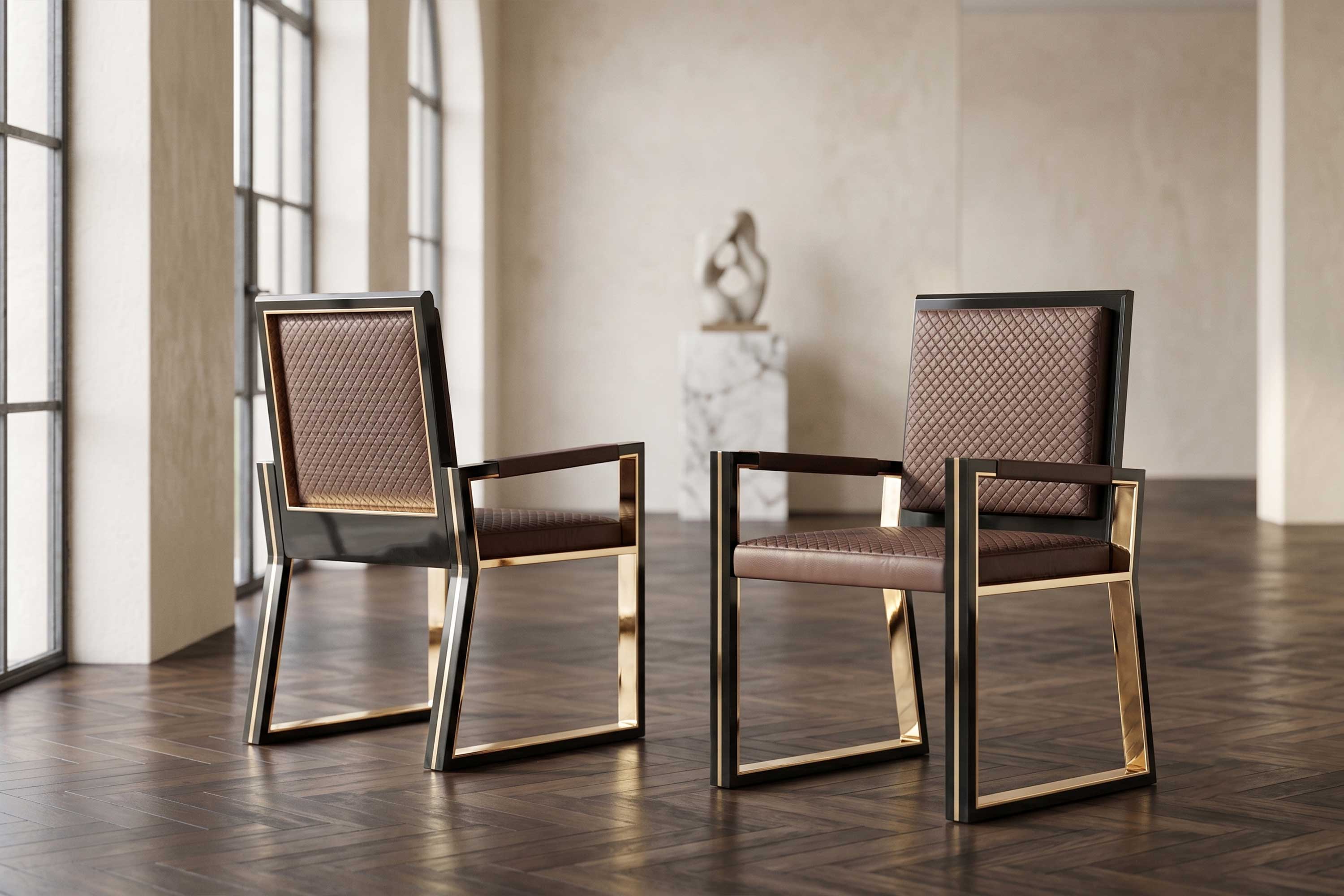 Two modern chairs with gold metal frames and brown cushioned seats are placed on a wooden floor in a minimalist room with large windows and a blurred sculpture in the background.
