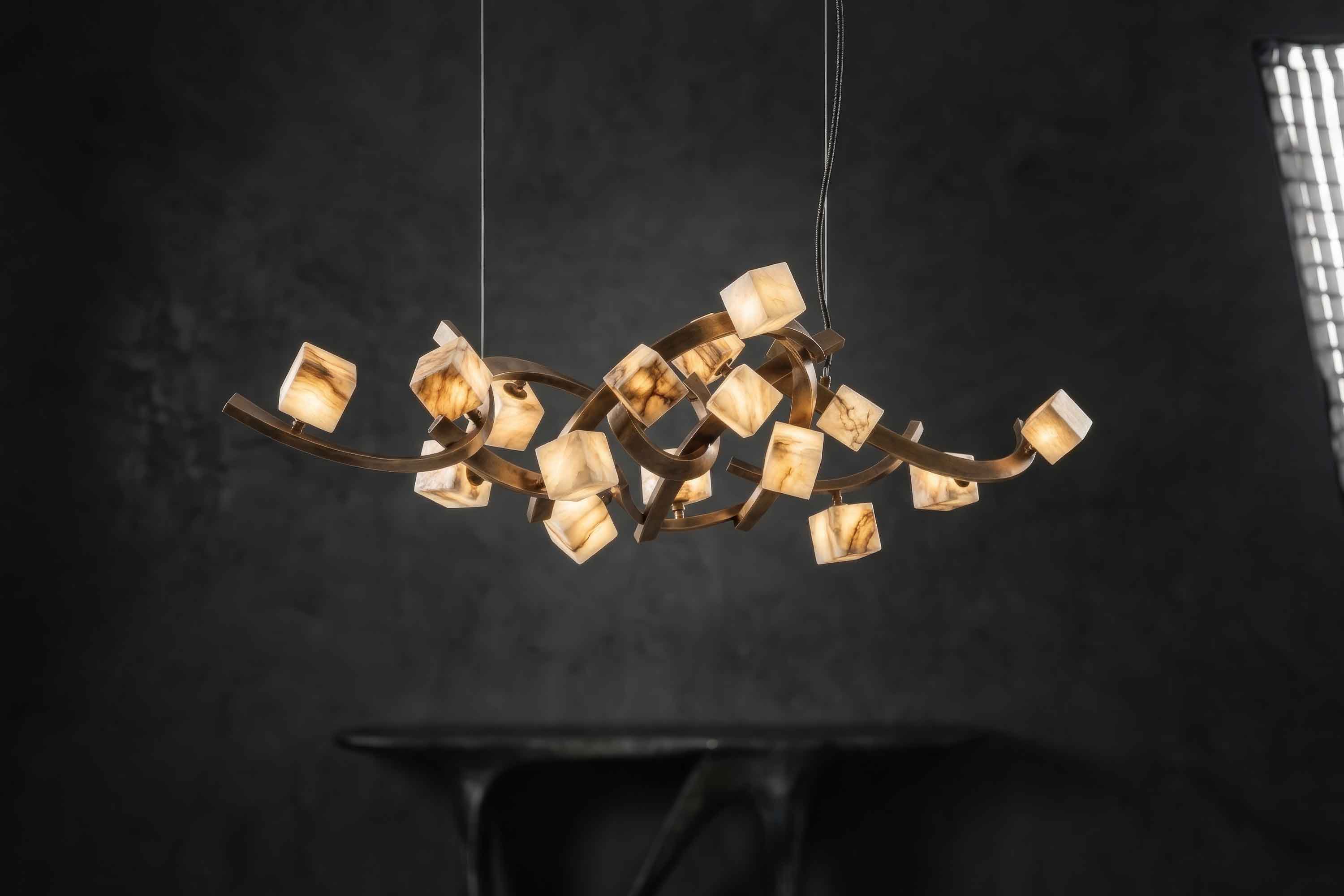 Cirro horizontal chandelier lit, glowing onyx cubes along bronze arcs