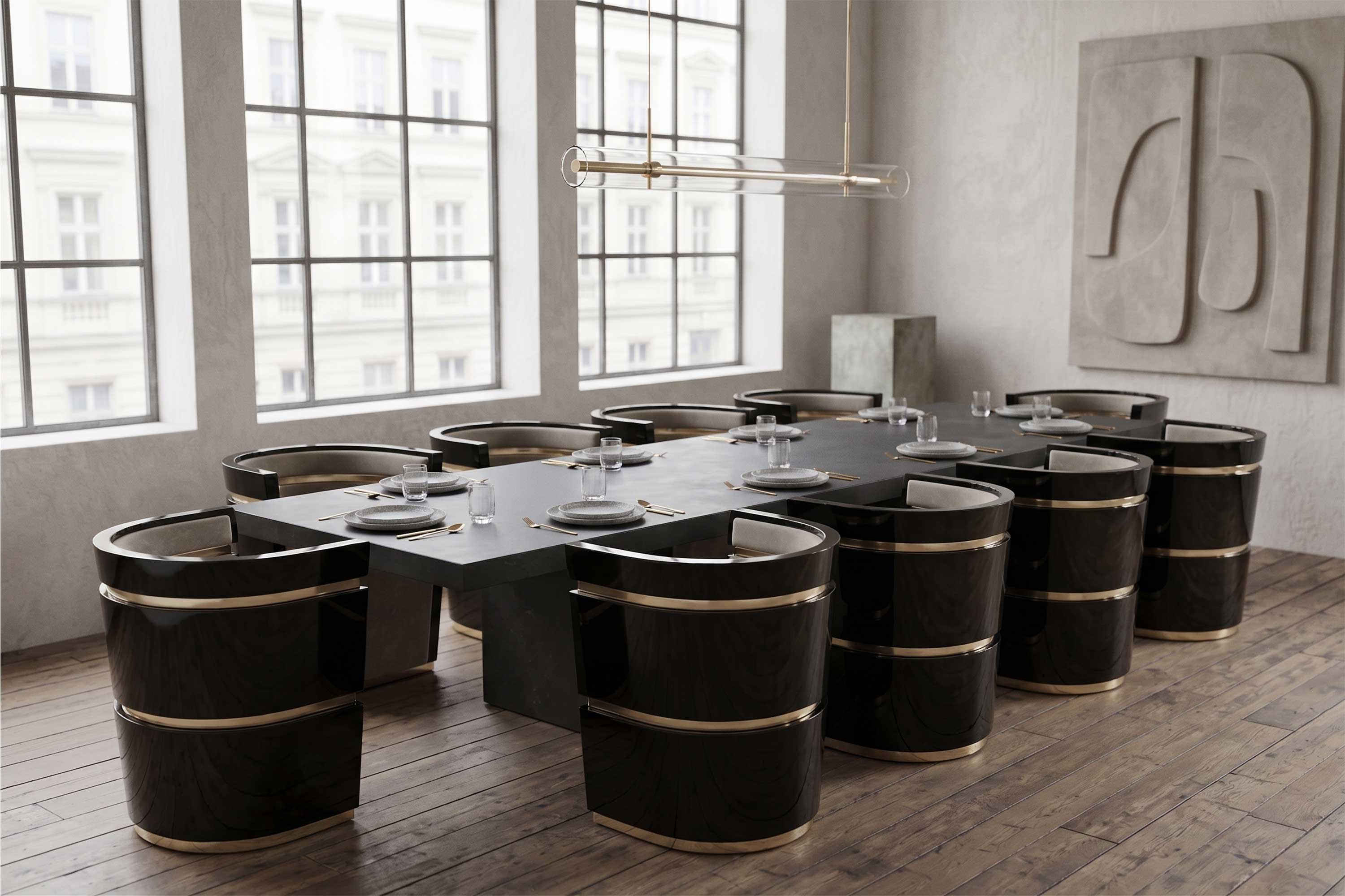 Modern dining room with a rectangular black table set for ten, surrounded by black and gold chairs. Large windows show a building outside. Minimalist wall art and pendant light fixture complete the setting.