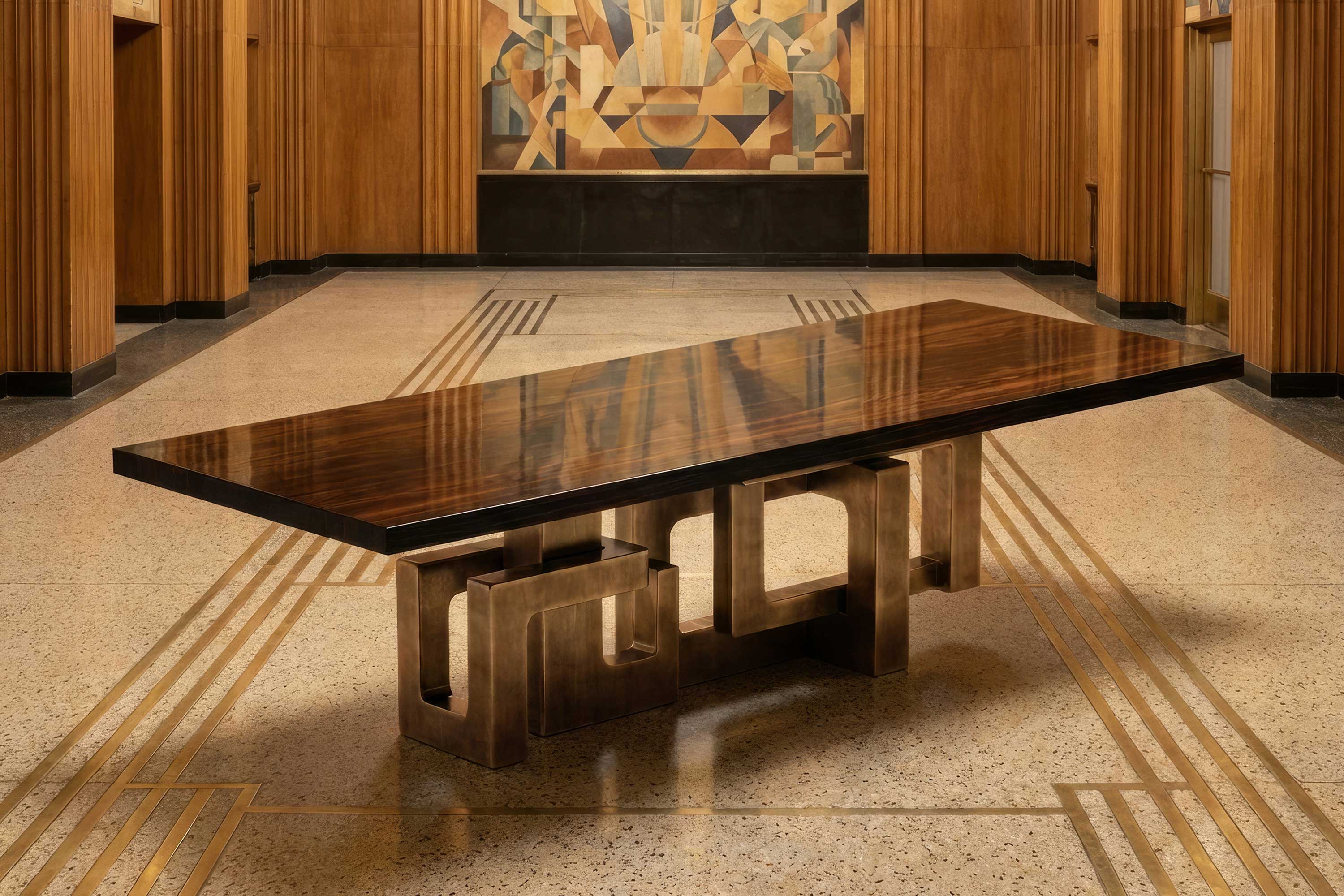 Labirinto Dining Table in patina bronze, sculptural dining table staged in a warm dark interior with rich timber wall panelling — Palena Studio