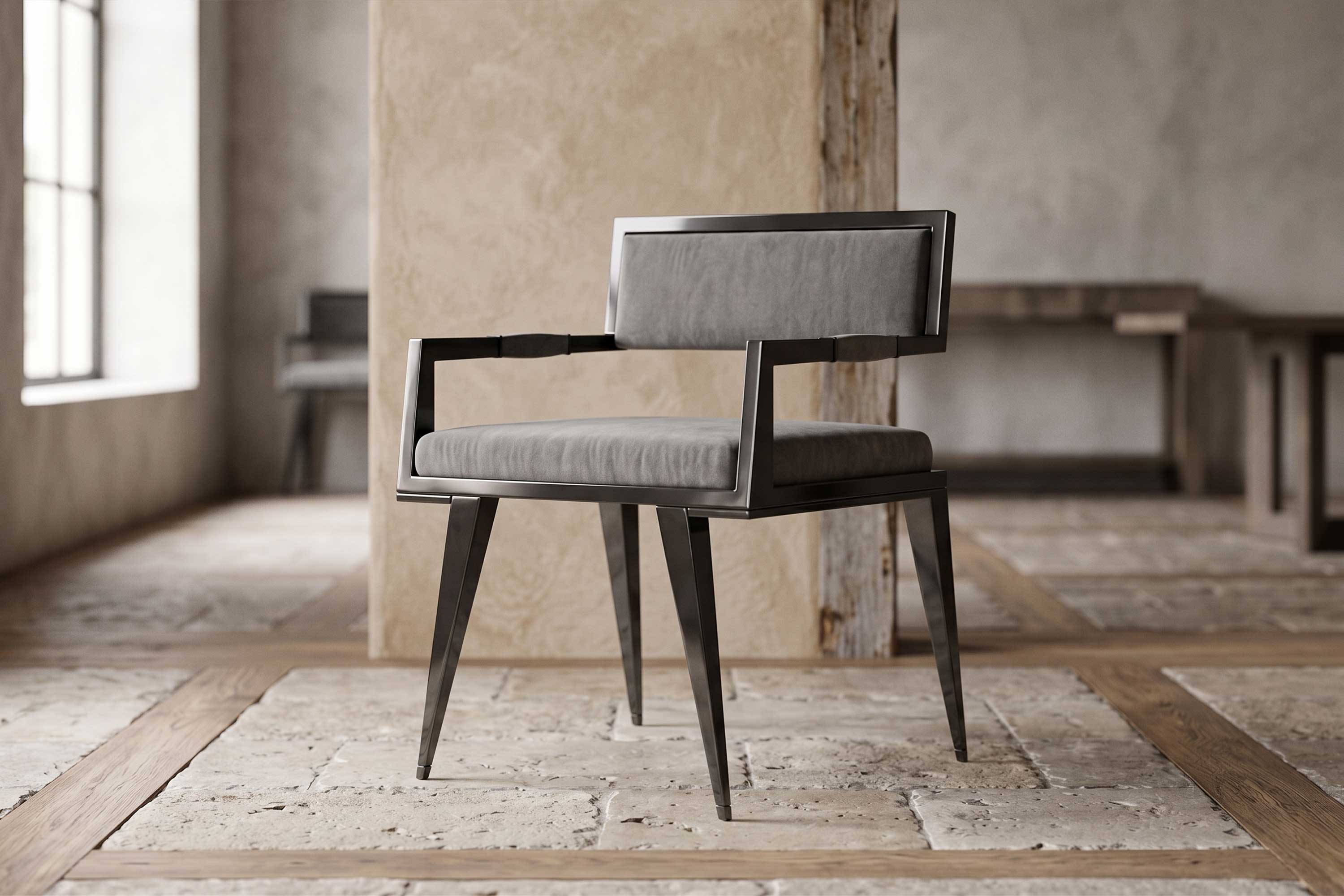 A modern chair with a black metal frame and gray cushioned seat and backrest sits in a room with stone tile flooring, plastered walls, and wooden beams. Light enters from a large window on the left.