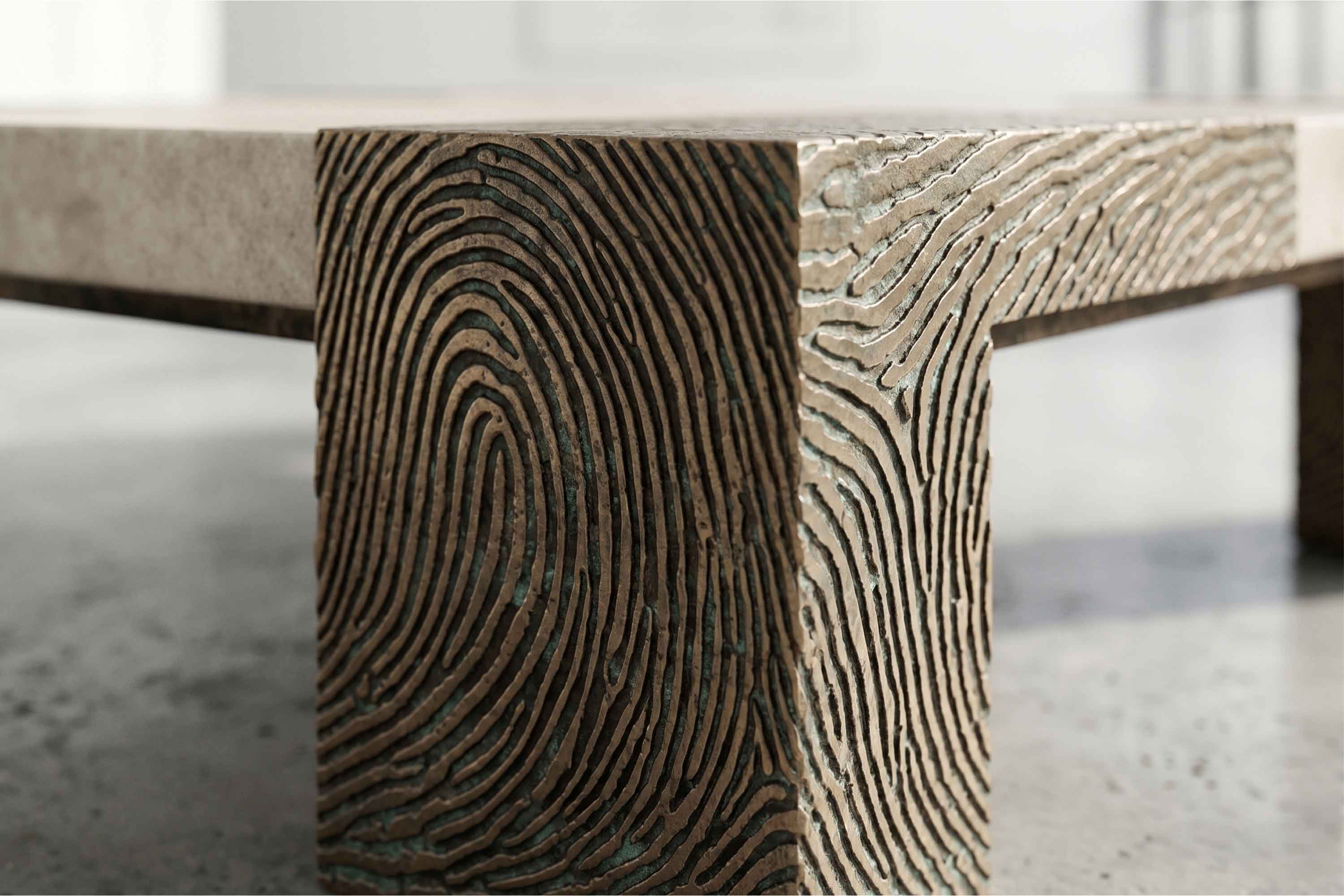 Close-up of a table leg featuring a detailed fingerprint pattern carved into the surface, with a smooth tabletop and a minimalist, modern design.