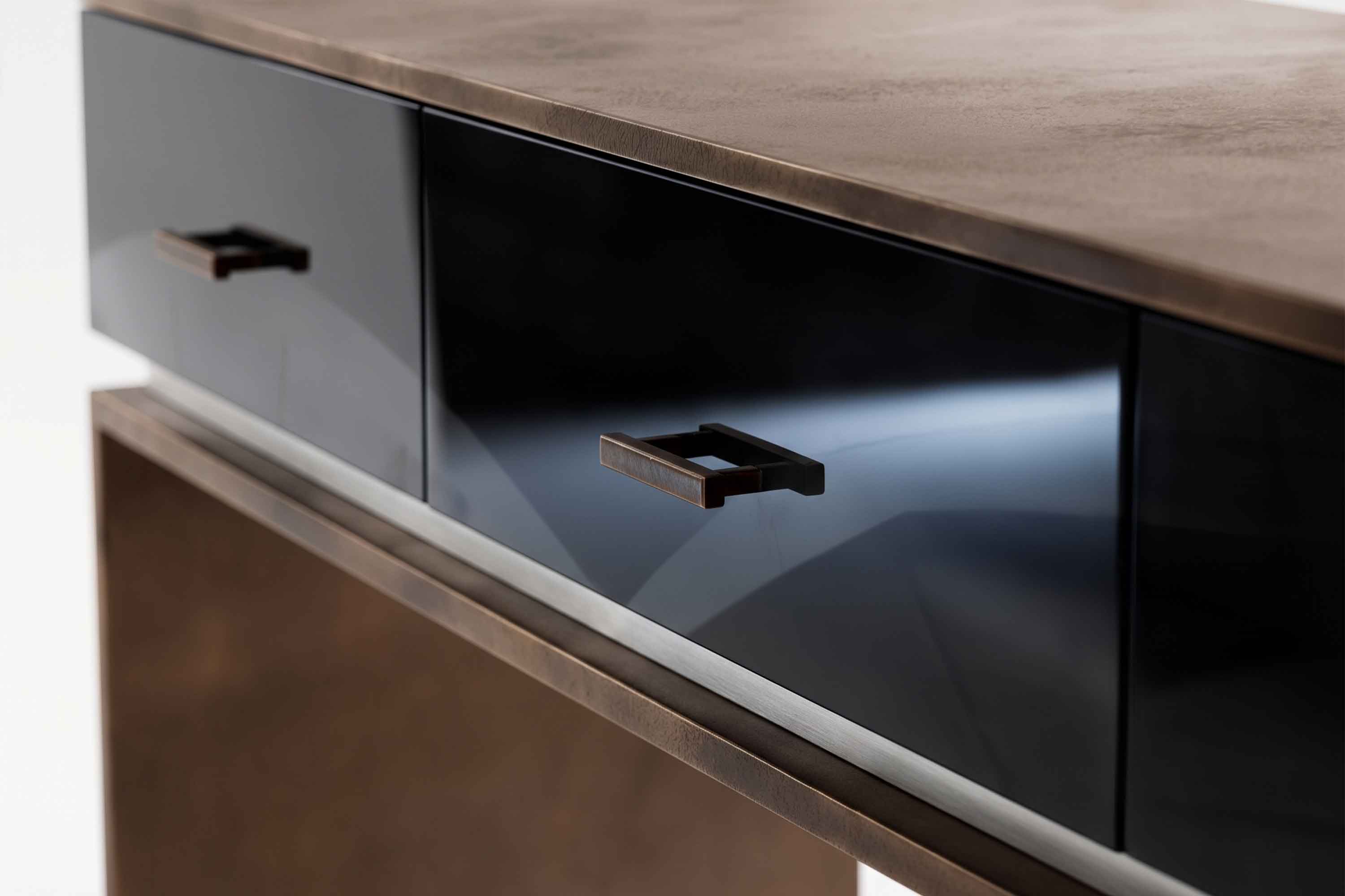 Detail of the Block Console, with a glossy black lacquer drawer, a slim bronze handle and the patina bronze top edge and leg.